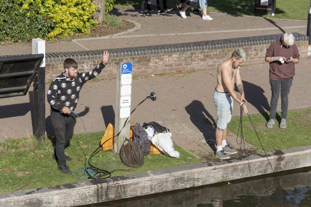 magnet fishing people throwing magnet in river