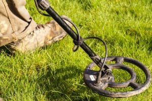 Metal Detector. Man with metal detector , he uses it to find archaeological treasures in the grass