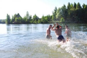 In the summer, the boys are swimming in the lake, diving, splash